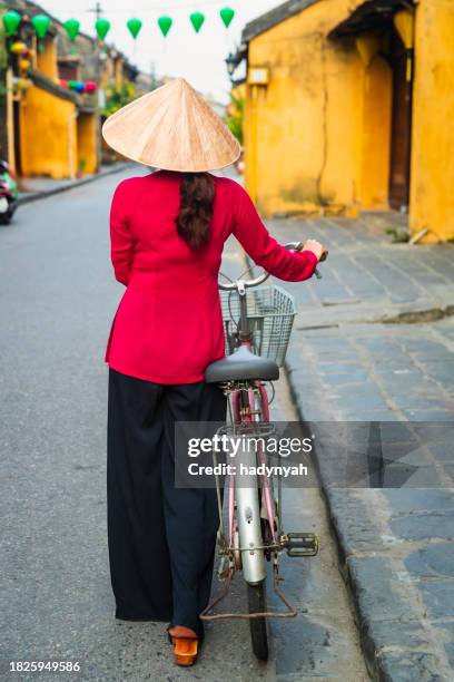 vietnamese woman with a bicycle, old town in hoi an city, vietnam - traditional clothing stock pictures, royalty-free photos & images