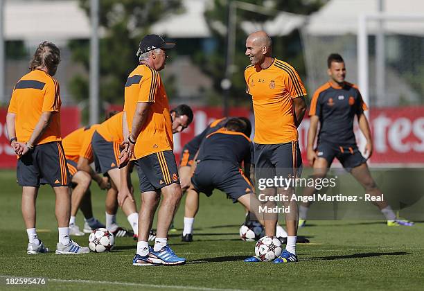 Head coach Carlo Ancelotti and his assistant Zinedine Zidane of Real Madrid chat during a training session ahead of their UEFA Champions League match...