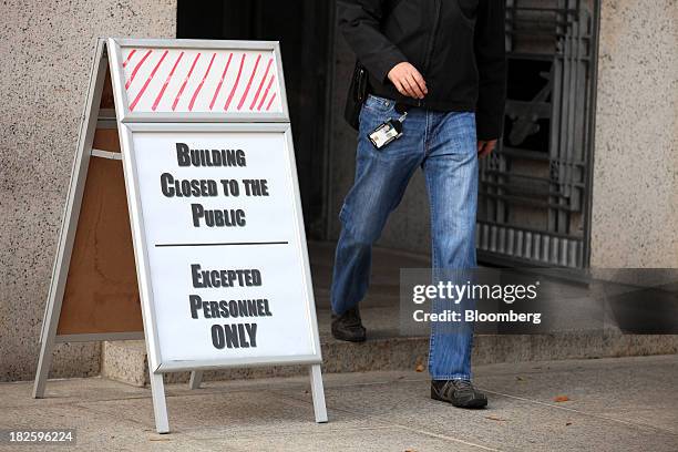 Sign explains that only exempted employees could remain at work at the Federal Trade Commission in Washington D.C., U.S., on Tuesday, Oct. 1, 2013....