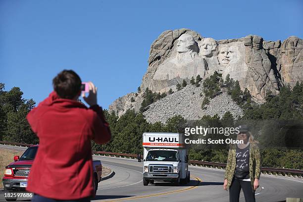 Barb Wleklinski and her daughter Danielle stop to take a picture near the entrance to Mount Rushmore National Memorial on October 1, 2013 in...