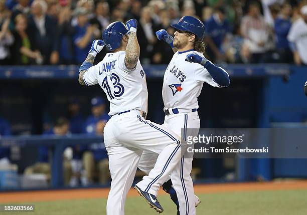 Colby Rasmus of the Toronto Blue Jays celebrates his two-run home run in the fourth inning with Brett Lawrie during MLB game action against the New...