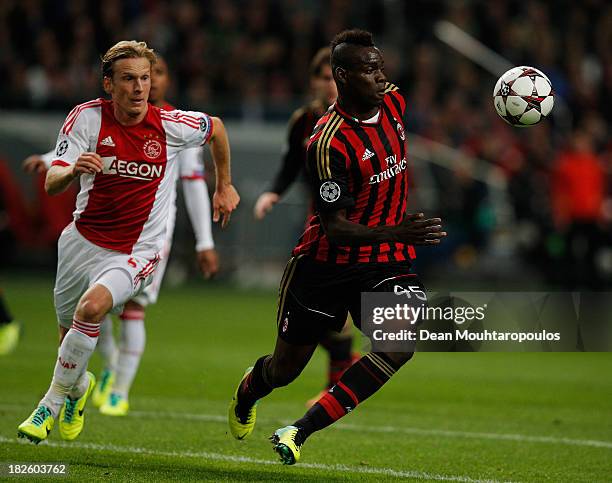 Christian Poulsen of Ajax is beaten to the ball by Mario Balotelli of AC Milan during the UEFA Champions League Group H match between Ajax Amsterdam...