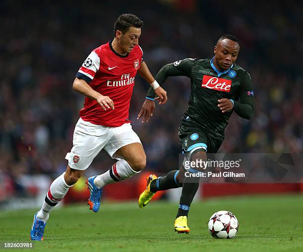 Mesut Oezil of Arsenal goes past Camilo Zuniga of Napoli during UEFA Champions League Group F match between Arsenal FC and SSC Napoli at Emirates...