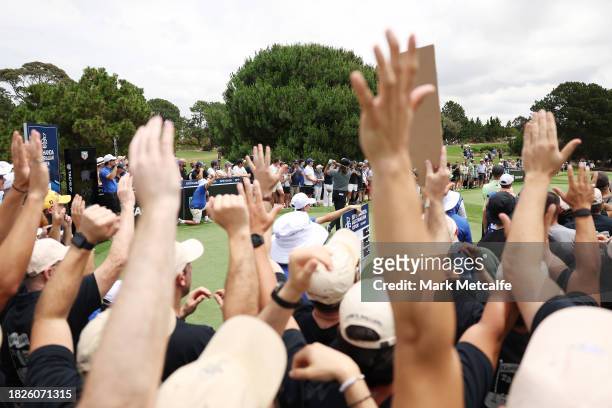 Fans cheer as they watch Aaron Baddeley of Australia tee off on the 11th tee during the ISPS HANDA Australian Open at The Australian Golf Course on...