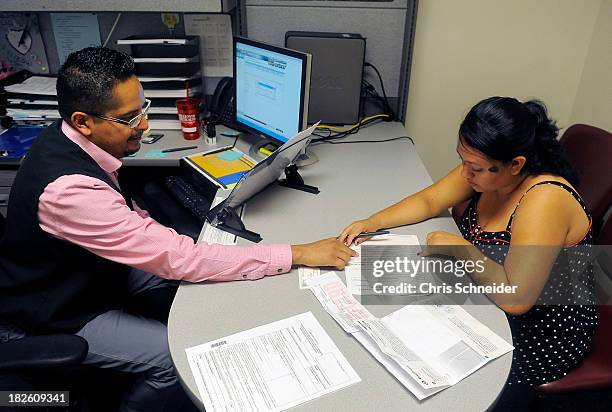 Enrollment Specialist Horacio Castaneda, left, helps Rosa Ayala Cruz, right, apply for health benefits at the Denver Health Westside Family Health...