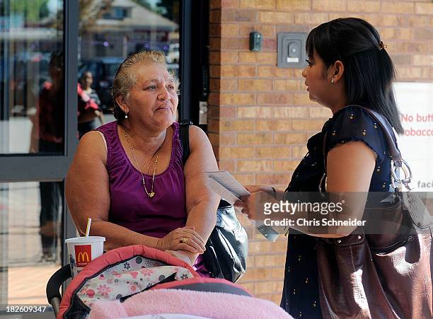 Lida Galindo, right, of Servicios de la Raza, talks with Mirian Morales left, about the Affordable Care Act outside of the Denver Health Westside...
