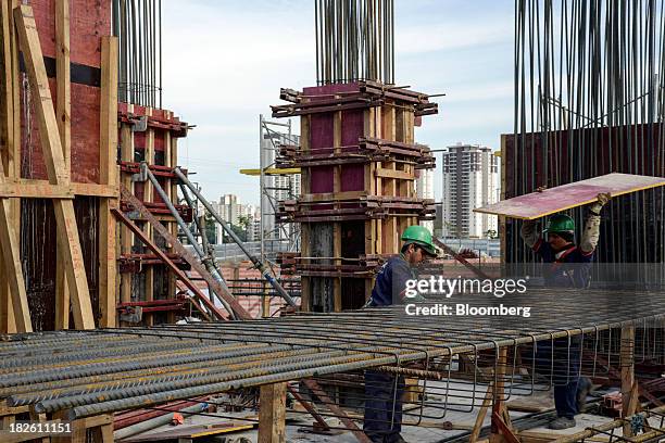 Worker carries a piece of plywood at the construction site of Tecnisa SA's Jardim das Perdizes housing development in Sao Paulo, Brazil, on Friday,...