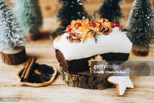 christmas cake on cut of a tree, sweets, orange slices, cinnamon and christmas trees. - lob wedge stock-fotos und bilder