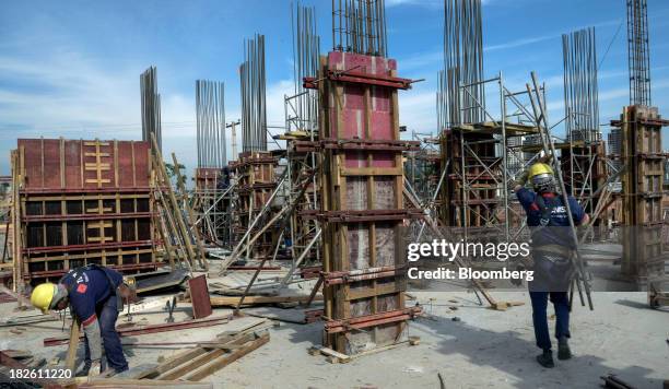 Worker carries metal rods at the construction site of Tecnisa SA's Jardim das Perdizes housing development in Sao Paulo, Brazil, on Friday, Sept. 27,...