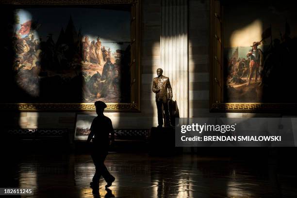 Capitol Police Officer walks past a statue of Gerald Ford, who was US president during the 1976 shutdown of the federal government, in the Rotunda...