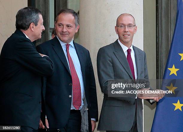 European Central Bank President Mario Draghi speaks with members of ECB Executive Board, Benoit Coeure and Jorg Asmussen, as they leave, on October 1...