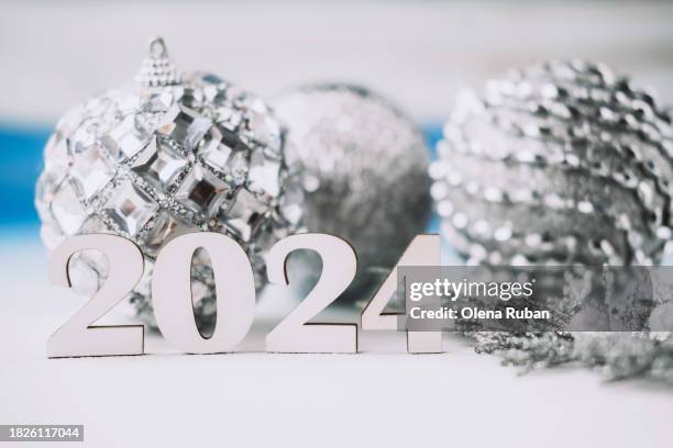 white wooden 2024 near silverish christmas toy balls on light surface. - yule marble stock pictures, royalty-free photos & images