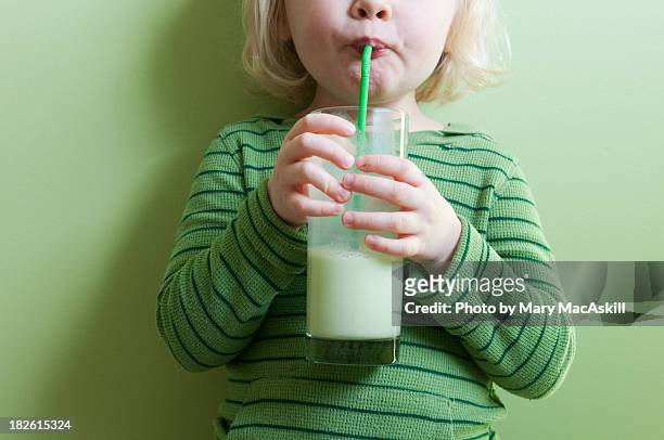 girl in green sipping green milkshake - rietje stockfoto's en -beelden