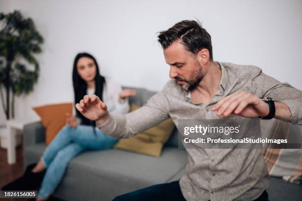 mid adult man and young woman arguing over personal differences - mad girlfriend stock pictures, royalty-free photos & images