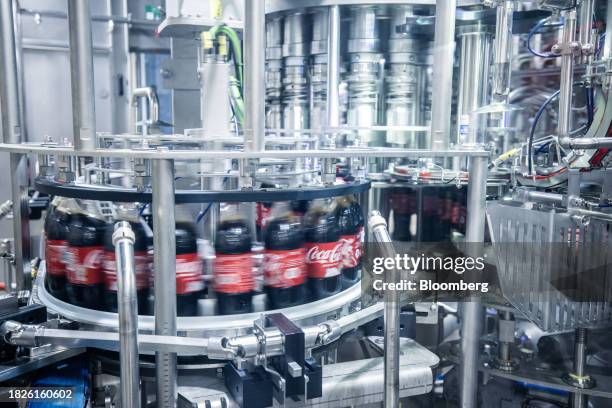 Bottles of Coca-Cola move through a labelling machine on the production line at the Coca-Cola HBC bottling plant in Dunaharaszti, Hungary, on...
