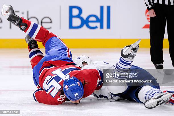 George Parros of the Montreal Canadiens falls to the ice head first during the third period fight with Colton Orr of the Toronto Maple Leafs during...