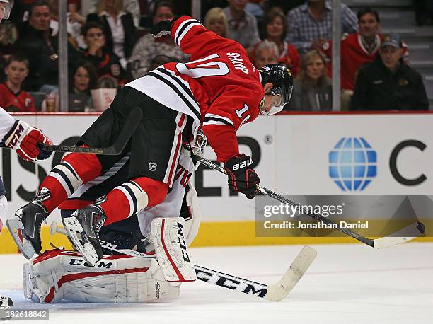 Patrick Sharp of the Chicago Blackhawks falls over Braden Holtby of the Washington Capitals and is called for goaltender interference at the United...