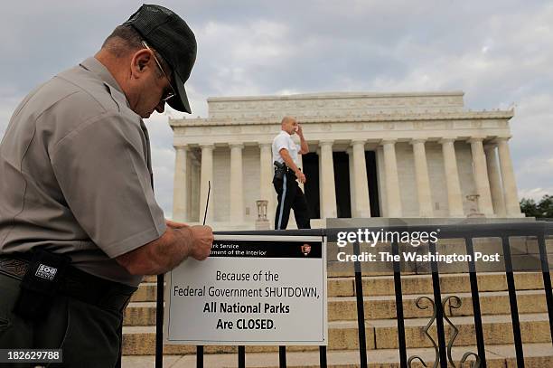 Richard Trott of the National Park Service puts up a sign announcing the closure of the Lincoln Memorial due to the government shutdown on Tuesday...