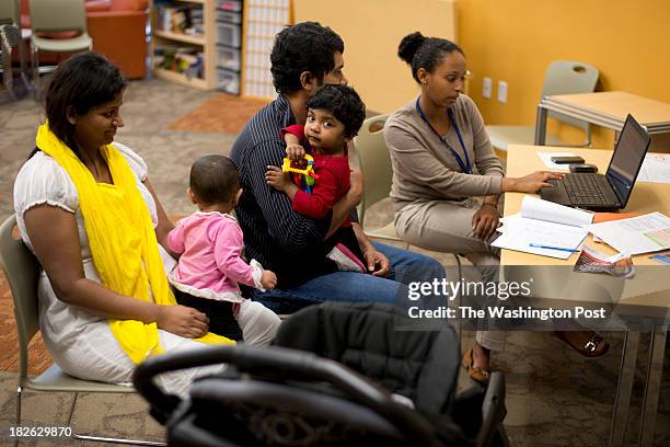 Betel Aklilu assists Mohammad Goni and his family with enrollment into Obamacare at Mary's Center in Washington, DC on October 01, 2013. From left to...