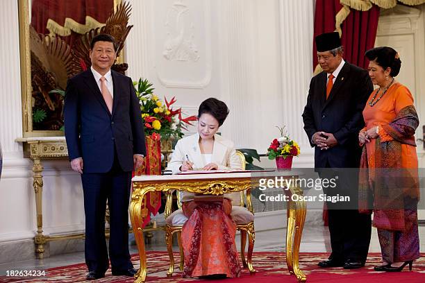 Wife of President of the people's Republic of China wife Peng Liyuan signs a credential book accompanied by Indonesian President Susilo Bambang...