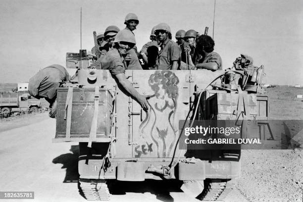 Israeli soldiers smile as they move atop an armoured personnel vehicle forwards the Syrian lines on the Syrian Golan Heights, a few days after the...