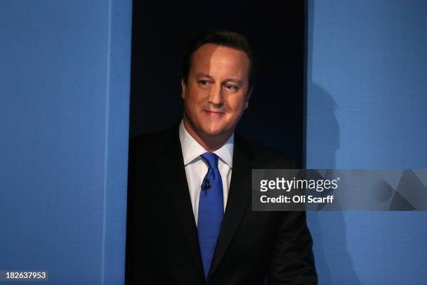 British Prime Minister David Cameron enters the stage to deliver his keynote speech on the last day of the annual Conservative Party Conference at...