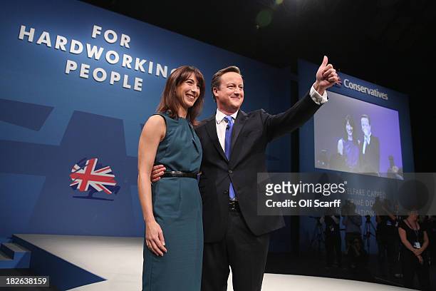 British Prime Minister David Cameron thanks the audience with his wife Samantha after delivering his keynote speech on the last day of the annual...
