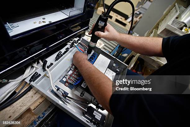 An employee works on the electrics for an AGA 3-oven Total Control range cooker, produced by AGA Rangemaster Plc, during the manufacturing process at...