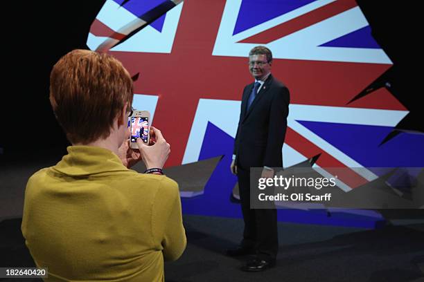 Delegate has his picture taken in front of a giant model of the Conservative Party logo after British Prime Minister David Cameron delivered his...