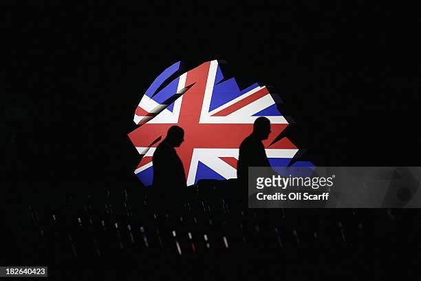 Delegates walk past a giant model of the Conservative Party logo before British Prime Minister David Cameron delivers his keynote speech to delegates...
