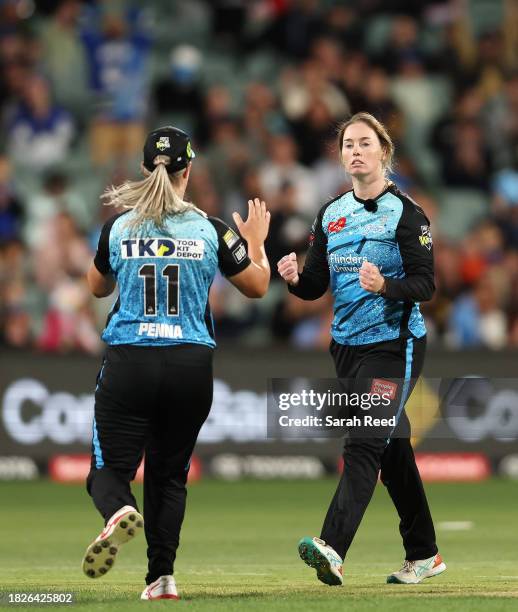 Amanda-Jade Wellington of the Adelaide Strikers celebrates the wicket of Mikayla Hinkley of the Brisbane Heat with Maddie Penna of the Adelaide...