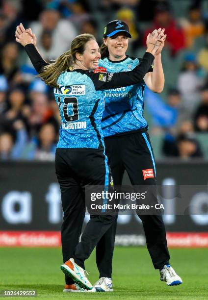 Amanda-Jade Wellington of the Adelaide Strikers celebrates the wicket of Georgia Redmayne of the Brisbane Heat with Tahlia McGrath captain of the...