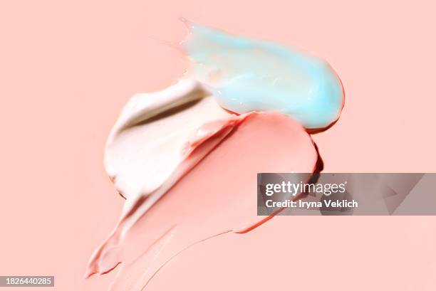texture of cosmetic products - skincare face cream, refreshing hydration water cream or face gel, hair mask, hand cream and face serum on natural pastel pink colour background. - haarbehandeling stockfoto's en -beelden