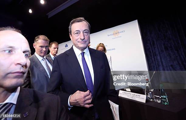Mario Draghi, president of the European Central Bank , center, leaves after speaking during the ECB's interest rate news conference held at the...