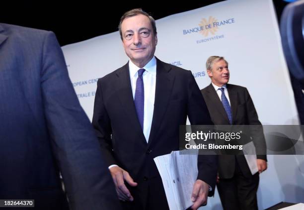 Mario Draghi, president of the European Central Bank , center, and Christian Noyer, governor of the Bank of France, right, leave after speaking...