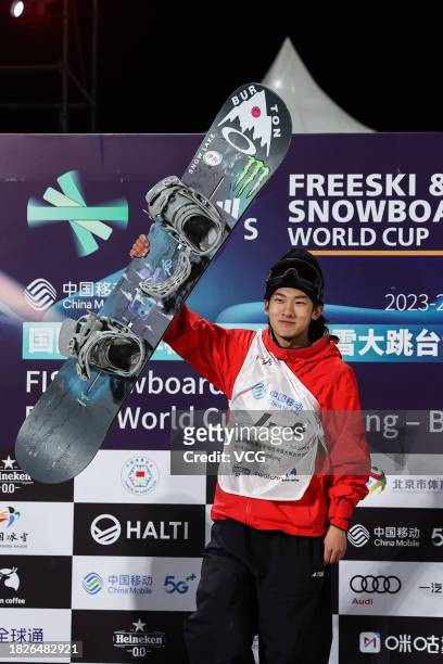 First place winner Su Yiming of China celebrates on the podium after the Men's Snowboard Big Air World Cup final at Big Air Shougang on December 2,...