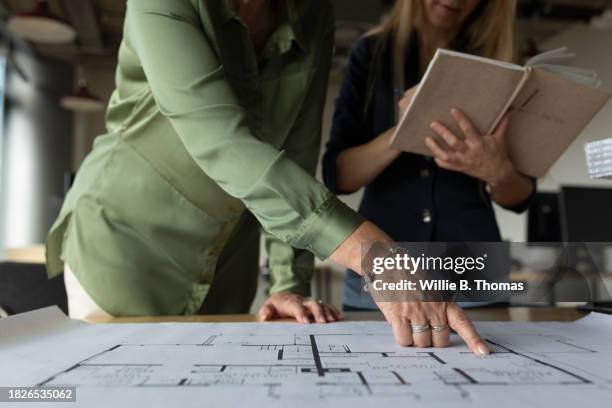 close up of architects analyzing floor plans while designing building together - planung stock-fotos und bilder