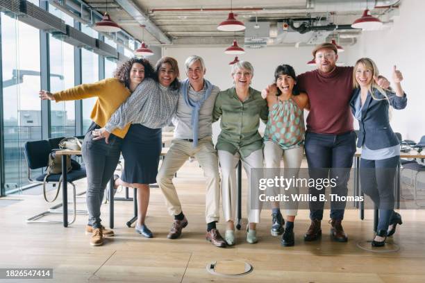 group of colleagues standing in middle of office for portrait - alle menschen stock-fotos und bilder