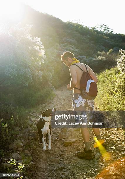 a hiker walks with his dog in the santa monica mountains in california. - halbbekleidet stock-fotos und bilder