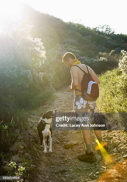 a hiker walks with his dog in the santa monica mountains in california. - santa monica mountains stock pictures, royalty-free photos & images