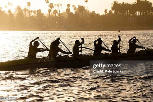 the women's santa barbara outrigger team paddles a six-person unlimited canoe off the coast of santa barbara, california. - outrigger stock pictures, royalty-free photos & images