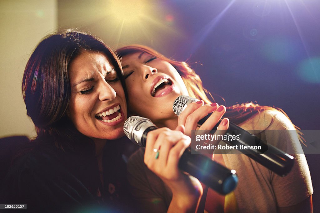 Two women singing karaoke.