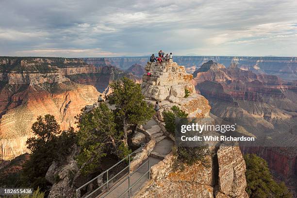 tourists gather at a viewpoint overlooking a grand canyon landscape. - north rim stock pictures, royalty-free photos & images