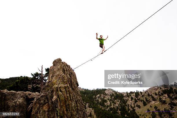 a male highliner walks the elephant buttresses highline in boulder canyon, colorado. - tightrope walker stock pictures, royalty-free photos & images