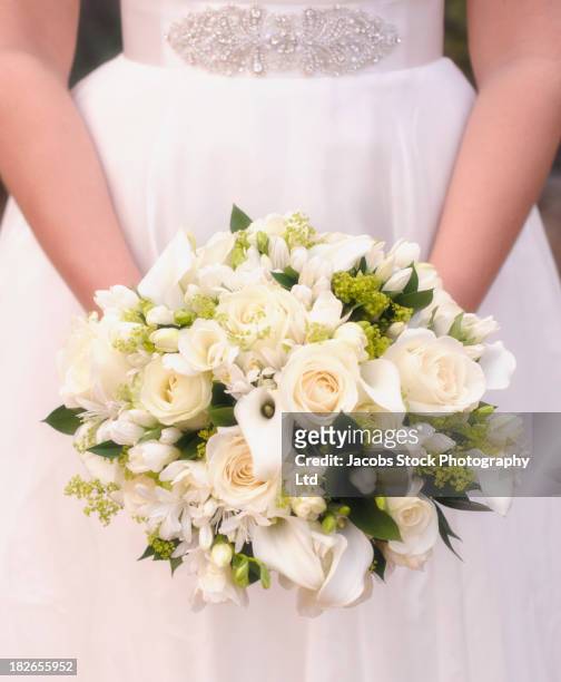 caucasian bride holding bouquet of white flowers - freesia fotografías e imágenes de stock