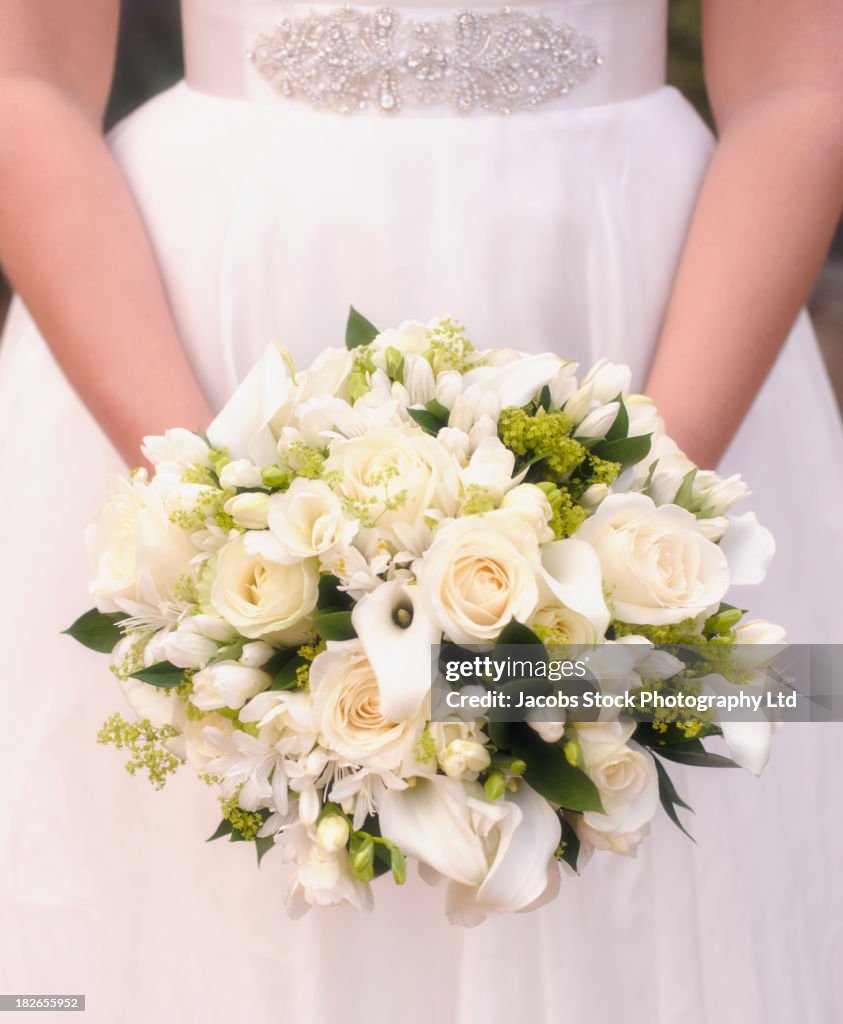 Caucasian bride holding bouquet of white flowers