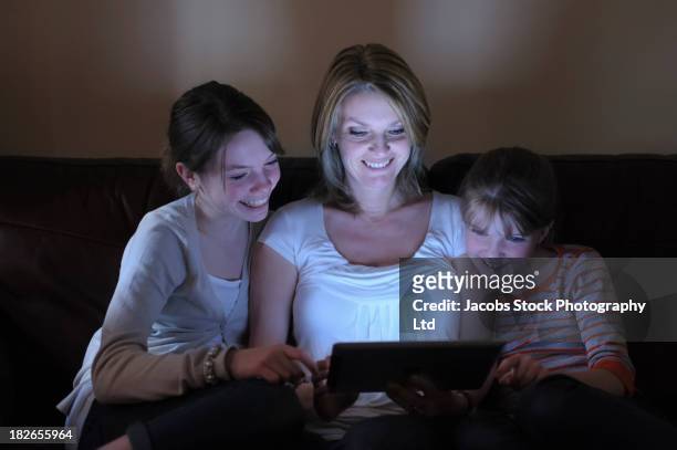 caucasian mother and daughters using tablet computer together - mamã filme de 2013 imagens e fotografias de stock