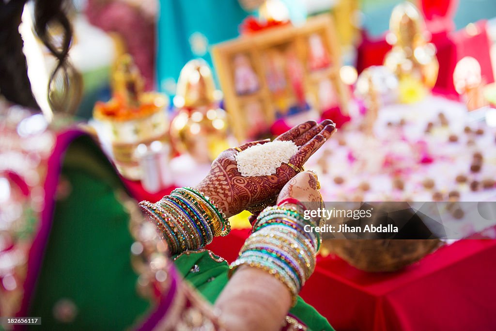 Indian woman in traditional garb with handful of rice