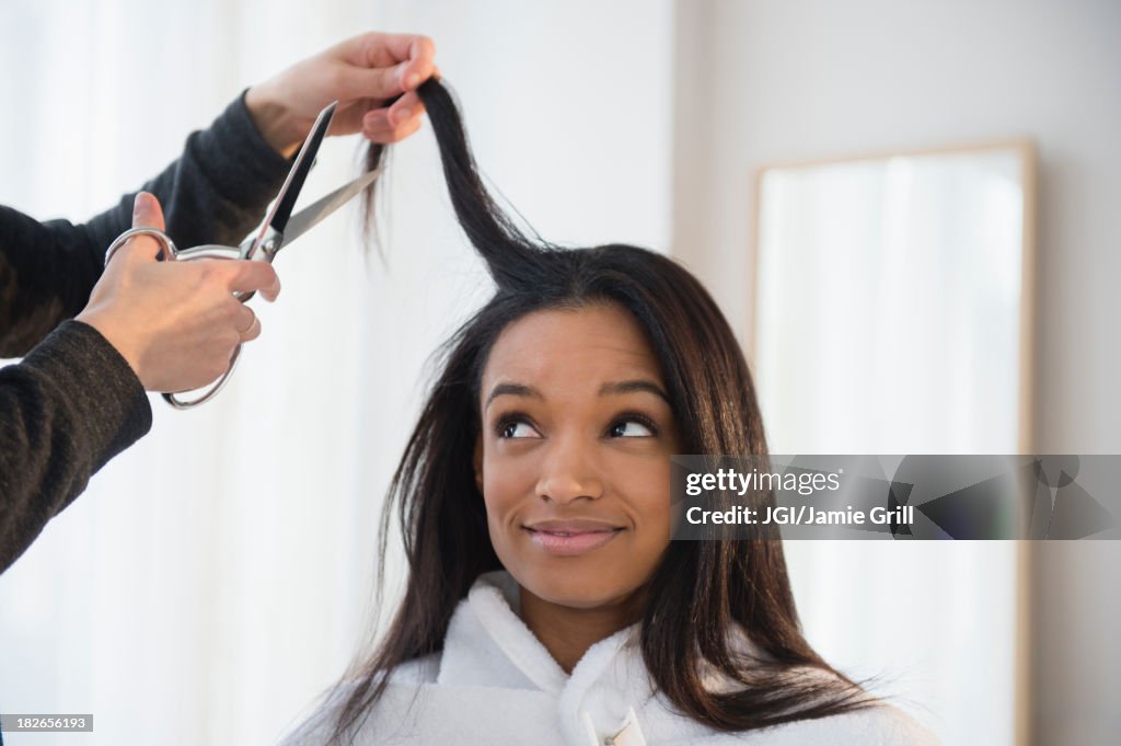 Mixed race woman getting hair cut