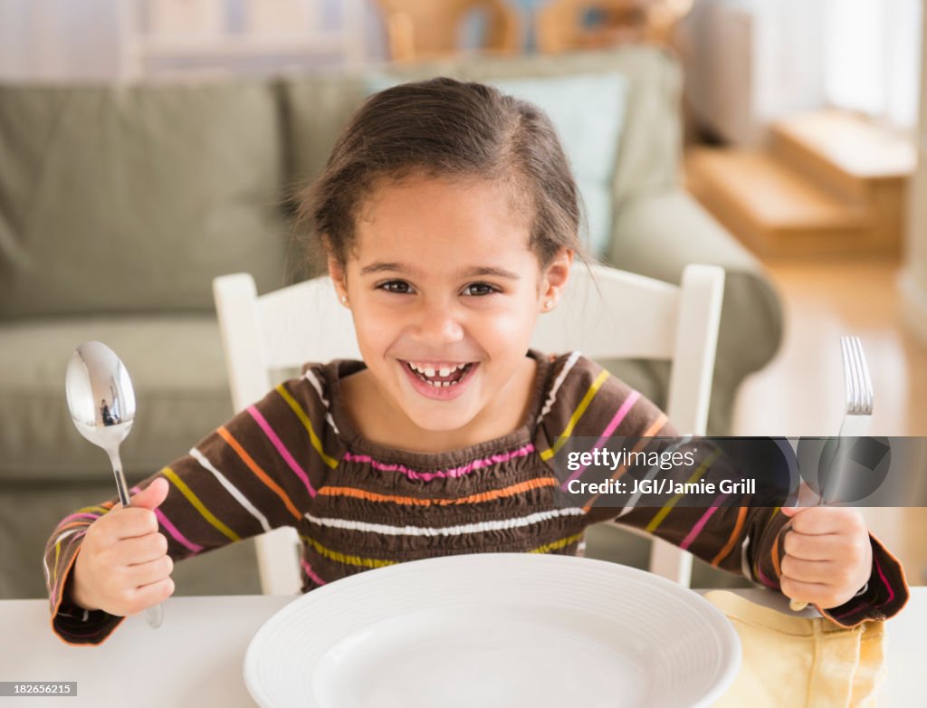Hispanic girl demanding food at table